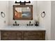 Bathroom featuring a double sink vanity with a rustic wood frame mirror and brushed metal fixtures at 4515 Red Rock Dr, Larkspur, CO 80118