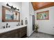 Rustic bathroom showcasing double sink vanity, wooden frame mirror and decorative accents, with a wood ceiling at 4515 Red Rock Dr, Larkspur, CO 80118