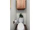 Clean and simple toilet area with overhead cabinet and tile floors, offers a functional and tidy space at 4515 Red Rock Dr, Larkspur, CO 80118