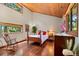 Cozy bedroom with hardwood floors, wood ceiling, bright windows, and a vintage-style rocking chair at 4515 Red Rock Dr, Larkspur, CO 80118