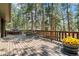Expansive wooden deck with railing, providing outdoor seating amidst mature trees, perfect for enjoying nature at 4515 Red Rock Dr, Larkspur, CO 80118