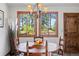 Bright dining area with wood table, chandelier, and large windows showcasing scenic views at 4515 Red Rock Dr, Larkspur, CO 80118