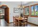 Dining room boasts natural light, stylish chandelier, and view through large windows at 4515 Red Rock Dr, Larkspur, CO 80118