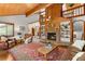 Bright, airy living room featuring a stone fireplace, built-in bookshelves, and comfortable seating at 4515 Red Rock Dr, Larkspur, CO 80118