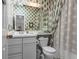 A quaint bathroom features a floral wallpaper and patterned shower curtain at 8040 E Dartmouth Ave # 16, Denver, CO 80231