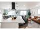 Modern kitchen island with white cabinets and quartz countertop, open to living area at 1173 Xenon St, Golden, CO 80401