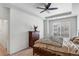 Cozy bedroom with a tray ceiling, a ceiling fan, and a window overlooking neighborhood at 23743 E Ida Pl # E, Aurora, CO 80016