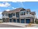 A modern townhome complex with a stone facade, multiple garage doors, and inviting curb appeal at 23743 E Ida Pl # E, Aurora, CO 80016