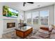 Bright living room featuring a cozy fireplace, TV, and large windows for natural light at 23743 E Ida Pl # E, Aurora, CO 80016