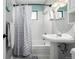 Well-lit bathroom features a shower-tub combo, classic white fixtures, and a pedestal sink at 3233 Meade St, Denver, CO 80211