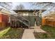 Home featuring a gray facade with wood accents, a small porch, and manicured garden spaces at 3233 Meade St, Denver, CO 80211