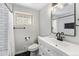 Bathroom featuring tiled shower and floors, vanity and a patterned window at 6538 S Lee Ct, Centennial, CO 80121