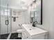 Modern bathroom featuring glass enclosed shower, updated vanity, matte fixtures, and black and white tiling at 6538 S Lee Ct, Centennial, CO 80121