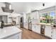 Bright kitchen featuring stainless appliances, white cabinets, wood floors and a beverage cooler at 6538 S Lee Ct, Centennial, CO 80121
