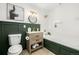 Modern bathroom with a soaking tub, white tile and dark green wainscoting at 475 W 12Th Ave # 6B, Denver, CO 80204