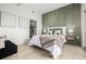 Bright bedroom with king-size bed and stylish green accent wall at 475 W 12Th Ave # 6B, Denver, CO 80204