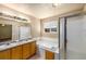 Bathroom with double sinks, a soaking tub, tiled walls, and a separate shower stall with a glass door at 21444 E Lehigh Ave, Aurora, CO 80013