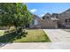 Charming home with a stone facade, well-manicured lawn, mature tree, and driveway leading to a two-car garage at 21444 E Lehigh Ave, Aurora, CO 80013