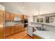 Well-lit kitchen featuring wood cabinetry, stainless steel appliances, and hardwood flooring with an adjacent eating area at 21444 E Lehigh Ave, Aurora, CO 80013