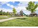 Community playground, climbing structures, and picnic area with lush greenery under a bright blue sky at 21444 E Lehigh Ave, Aurora, CO 80013