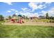 Community playground with slides, swings, and covered picnic area against a backdrop of blue skies and clouds at 21444 E Lehigh Ave, Aurora, CO 80013