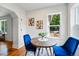 Bright dining room with hardwood floors, with bright-blue chairs and a view of the lush outside greenery at 3346 W 33Rd Ave, Denver, CO 80211