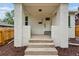 A welcoming front porch with white brick pillars, concrete steps, and a door with house numbers at 3346 W 33Rd Ave, Denver, CO 80211