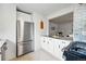 Bright kitchen featuring stainless steel appliances, white cabinetry, and stylish herringbone floors at 3346 W 33Rd Ave, Denver, CO 80211