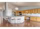Bright kitchen features wood floors, large island with seating, light wood cabinets and stainless steel appliances at 2132 Boise Ct, Longmont, CO 80504