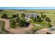 Expansive property featuring a well-manicured lawn, mature trees, and a circular driveway leading to the residence at 10515 Lucas Ave, Franktown, CO 80116