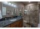 Bathroom featuring a granite countertop, wood cabinets, tiled shower and flooring at 10515 Lucas Ave, Franktown, CO 80116
