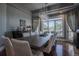 Elegant dining room featuring a long wooden table, modern lighting, and large windows with lush green views at 10515 Lucas Ave, Franktown, CO 80116