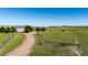 View of the home surrounded by fields and a gated entrance at 10515 Lucas Ave, Franktown, CO 80116