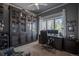 Dedicated home office space with custom built-in shelving and natural light from a large window at 10515 Lucas Ave, Franktown, CO 80116