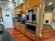 Modern kitchen with stainless steel double oven, black countertops, and natural wood cabinets at 10515 Lucas Ave, Franktown, CO 80116