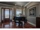 Cozy living room area featuring a grand piano with hardwood floors, soft lighting, and neutral décor at 10515 Lucas Ave, Franktown, CO 80116