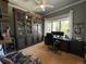 Home office with a large wooden desk, a floor-to-ceiling bookshelf, and a ceiling fan at 10515 Lucas Ave, Franktown, CO 80116