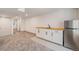 Finished basement featuring gray carpet, utility sink, stainless refrigerator and white cabinets at 9948 King St, Westminster, CO 80031