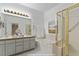 Bright bathroom featuring double vanity sinks, a tub, and a glass door shower at 13739 Legend Trl # 102, Broomfield, CO 80023
