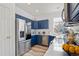 Stylish kitchen featuring stainless steel appliances, a corner sink, and navy blue cabinets at 13739 Legend Trl # 102, Broomfield, CO 80023