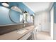 Stylish bathroom featuring dual sinks, round mirrors, and custom cabinetry at 2020 E 4Th Ave, Denver, CO 80206