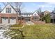 Traditional brick home featuring a landscaped lawn, a detached garage and a covered outdoor area at 2020 E 4Th Ave, Denver, CO 80206