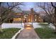 Charming brick home with a stone walkway leading to a front porch with accent lighting at dusk at 2020 E 4Th Ave, Denver, CO 80206