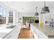 Bright and open kitchen features white cabinetry, marble countertops, and modern pendant lighting at 2020 E 4Th Ave, Denver, CO 80206