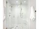 Elegant white tiled shower features dual shower heads and marble flooring at 2020 E 4Th Ave, Denver, CO 80206