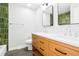 Stylish bathroom featuring a double sink vanity, modern fixtures, and a green tiled shower at 4682 Chatham St, Boulder, CO 80301