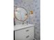 Powder room featuring stylish wallpaper, a round mirror, and modern fixtures at 230 Jasmine St, Denver, CO 80220