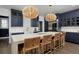 A modern kitchen with large island, bar seating, and navy cabinets provides an inviting gathering space at 230 Jasmine St, Denver, CO 80220