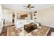 Bright living room features a plush white sectional, decorative rug, and views to the eat-in kitchen at 9238 Wolfdale Dr, Lone Tree, CO 80124