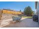 Spacious backyard with a stone retaining wall, patio, outdoor furniture, and barbecue for relaxation and entertaining at 8893 W Ontario Ave, Littleton, CO 80128